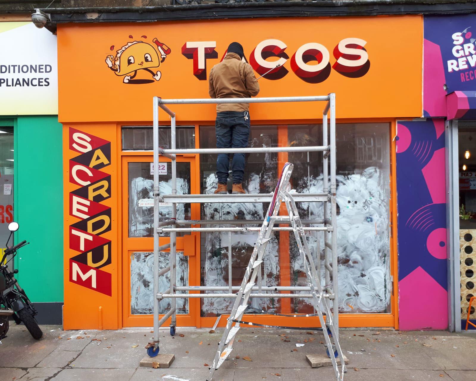 Ciaran Globel painting a shopfront