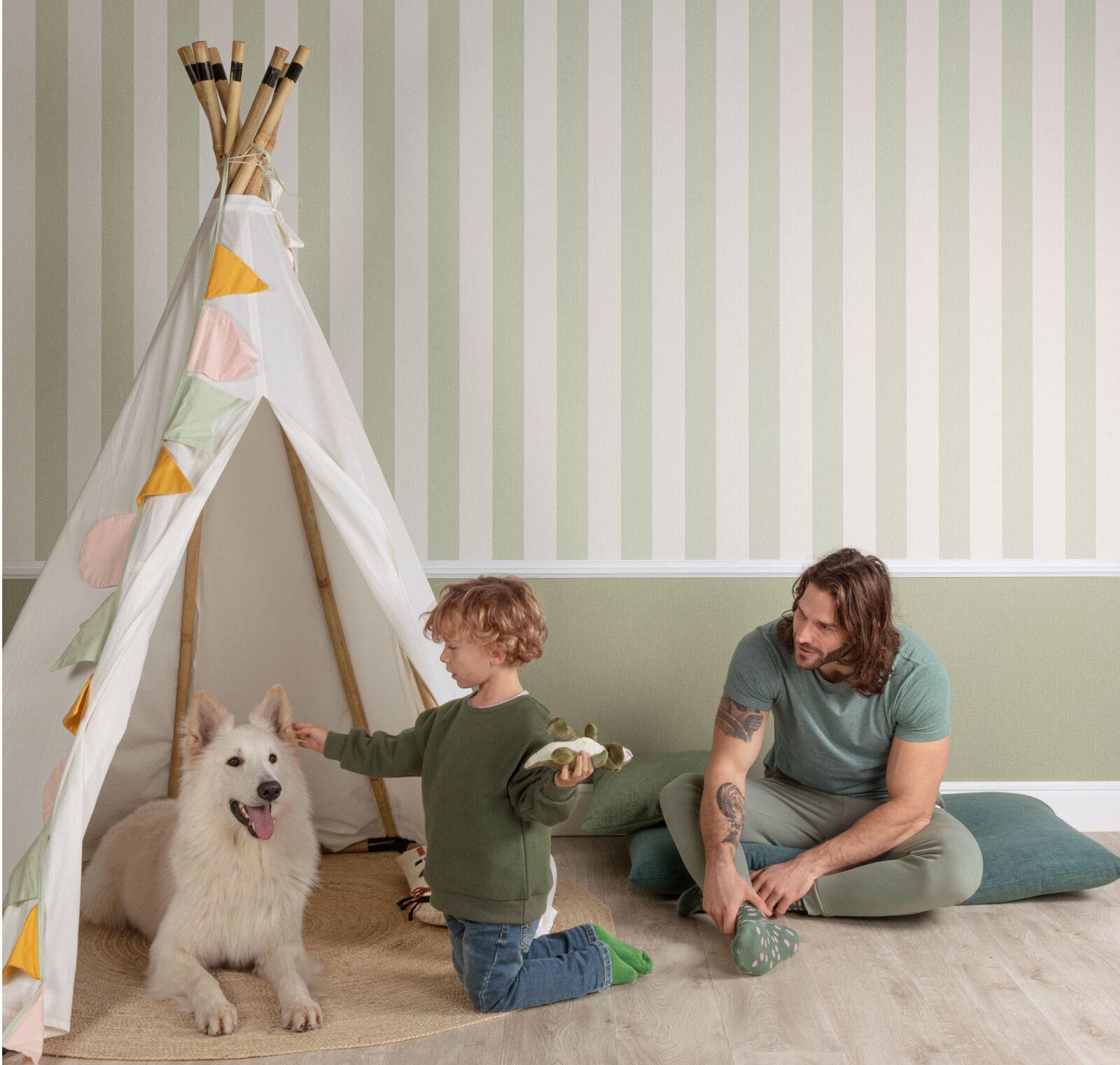 Child playing with dog while father looks on.