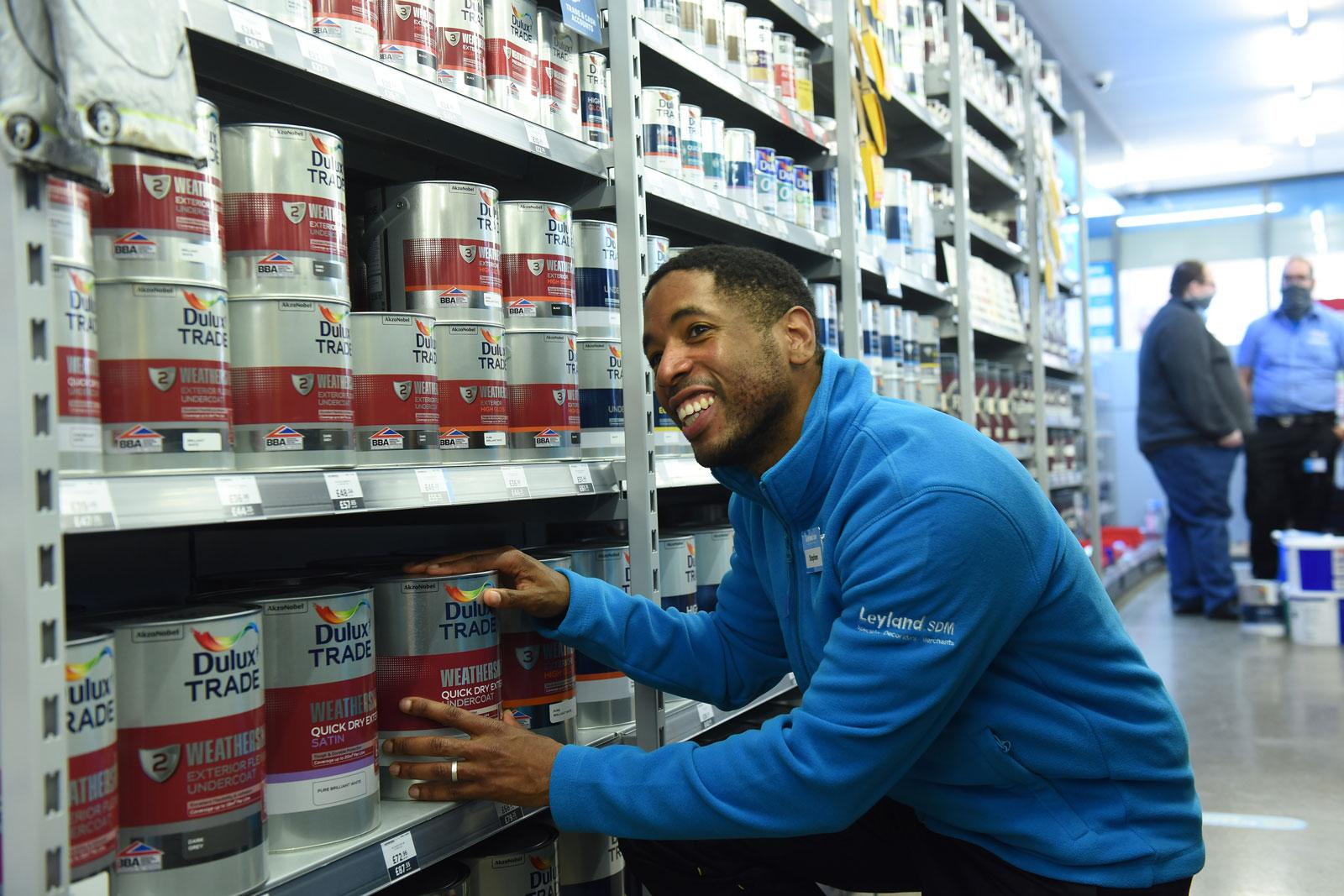 Photograph of a Leyland SDM staff member stacking shelves in the paint store.