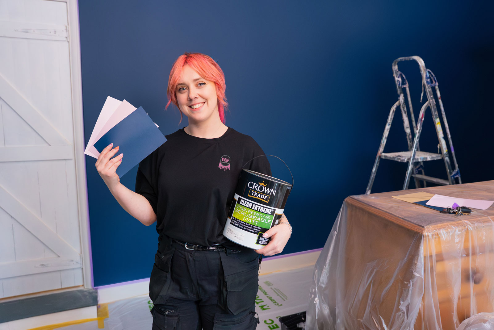Photograph of a female decorator holding a paint can.
